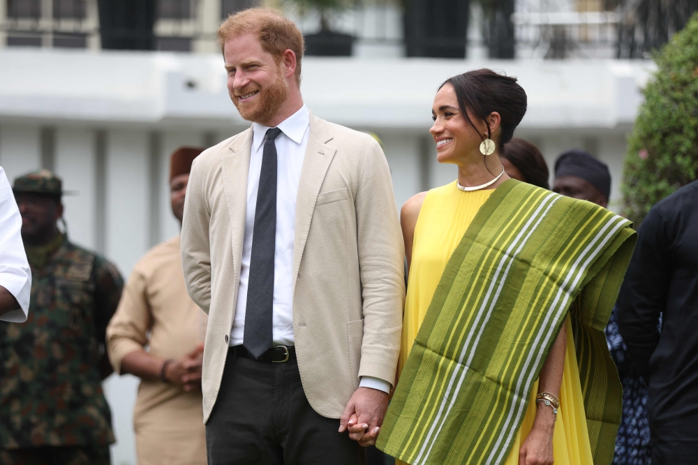 Britain's Prince Harry (2ndR), Duke of Sussex, and Britain's Meghan (R), Duchess of Sussex, react as Lagos State Governor, Babajide Sanwo-Olu (unseen), gives a speech at the State Governor House in Lagos on May 12, 2024 as they visit Nigeria as part of celebrations of Invictus Games anniversary. (Photo by Kola SULAIMON / AFP)
