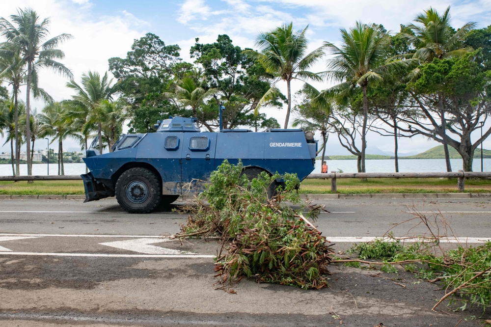 A Gendarmerie armored vehicle drives past the filtering roadblock set up on the bays, Promenade Pierre Vernier, in Noumea on May 15, 2024, amid protests linked to a debate on a constitutional bill aimed at enlarging the electorate for upcoming elections of the overseas French territory of New Caledonia. (Photo by Delphine Mayeur / AFP)
