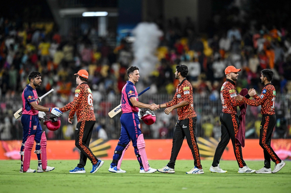 Sunrisers Hyderabad players (orange) are congratulated by Rajasthan Royals players after their win at the end of their IPL T20 second qualifier cricket match in the MA Chidambaram Stadium of Chennai on May 24, 2024. (Photo by R.Satish Babu / AFP) 