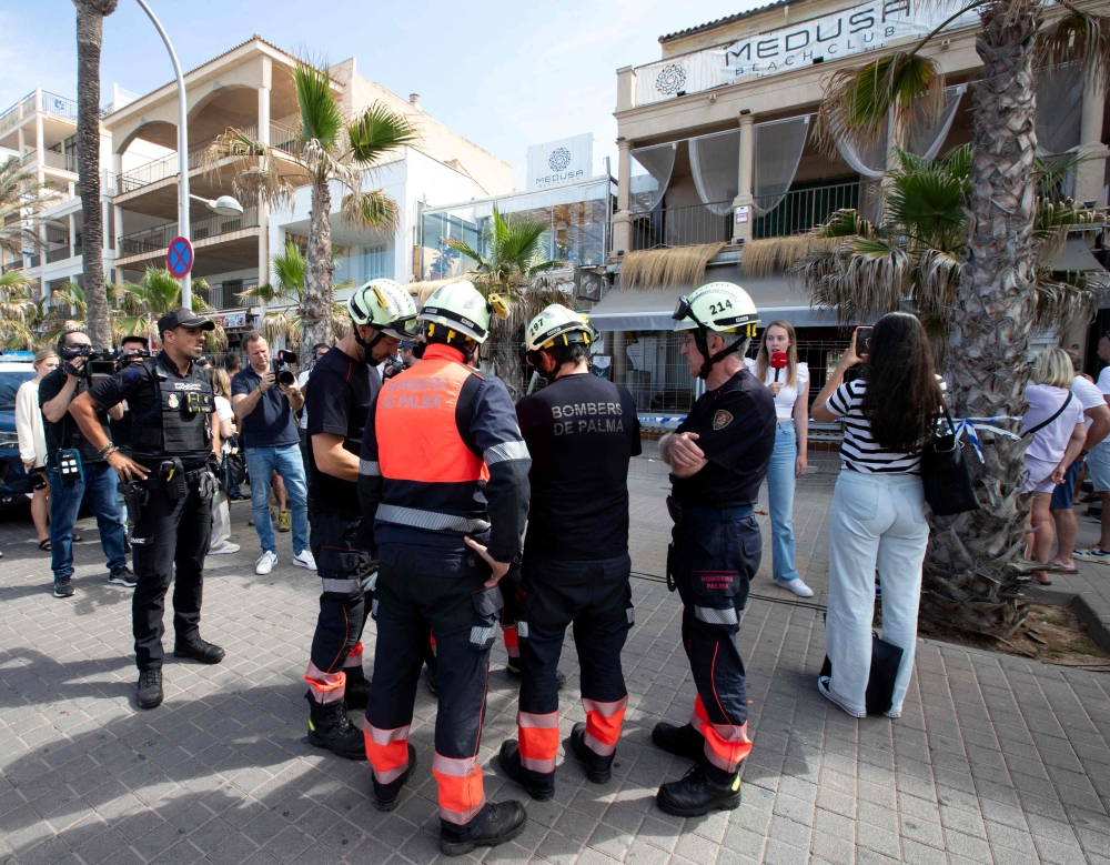 A Police officer investigates one day after a two-storey club-restaurant collapsed, killing four and injuring 16 people on Playa de Palma, south of the Spanish Mediterranean island's capital Palma de Mallorca, on May 24, 2024. Photo by Jaime REINA / AFP

