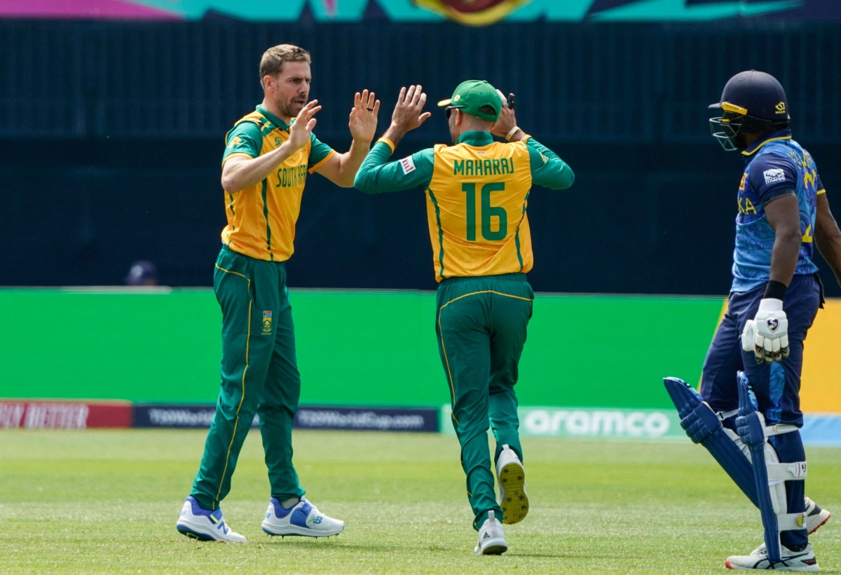 (L-R) South Africa's Anrich Nortje celebrates with South Africa's Keshav Maharaj (C) after Sri Lanka's Kamindu Mendis (R) is dismissed during the ICC men's Twenty20 World Cup 2024 group D cricket match between Sri Lanka and South Africa at Nassau County International Cricket Stadium in East Meadow, New York on June 3, 2024. (Photo by TIMOTHY A. CLARY / AFP)

