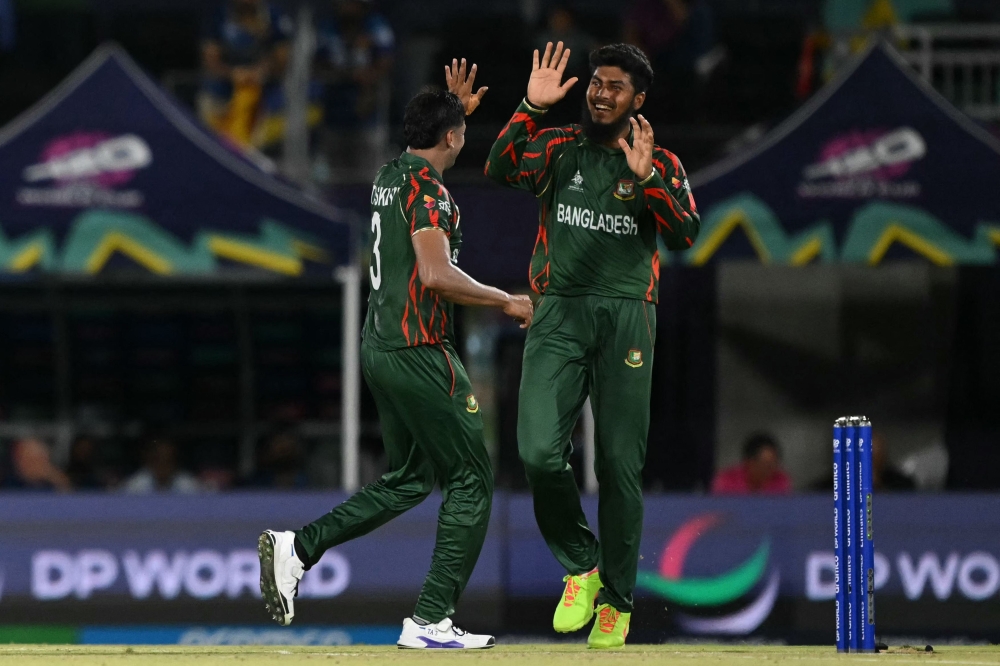 Bangladesh's vice-captain Taskin Ahmed (L) and Bangladesh's Rishad Hossain celebrate the dismissal of Sri Lanka's Dasun Shanaka (out of frame) at the Grand Prairie Cricket Stadium in Grand Prairie, Texas, on June 7, 2024. (Photo by Andrew Caballero-Reynolds / AFP)
 