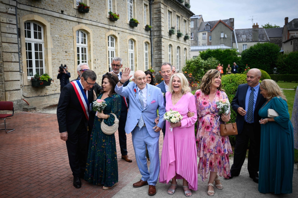 US WWII veteran Harold Terens, 100, (L) and Jeanne Swerlin, 96, (R) gesture as they arrive for their wedding in Normandy on June 8, 2024 (Photo by Loic Venance / AFP)