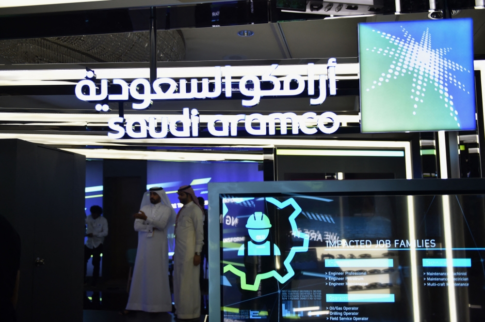 (Files) Visitors stop at the Aramco exhibition section at the Misk Global Forum on innovation and technology held in the Saudi capital Riyadh on November 13, 2019. (Photo by Fayez Nureldine / AFP)
 