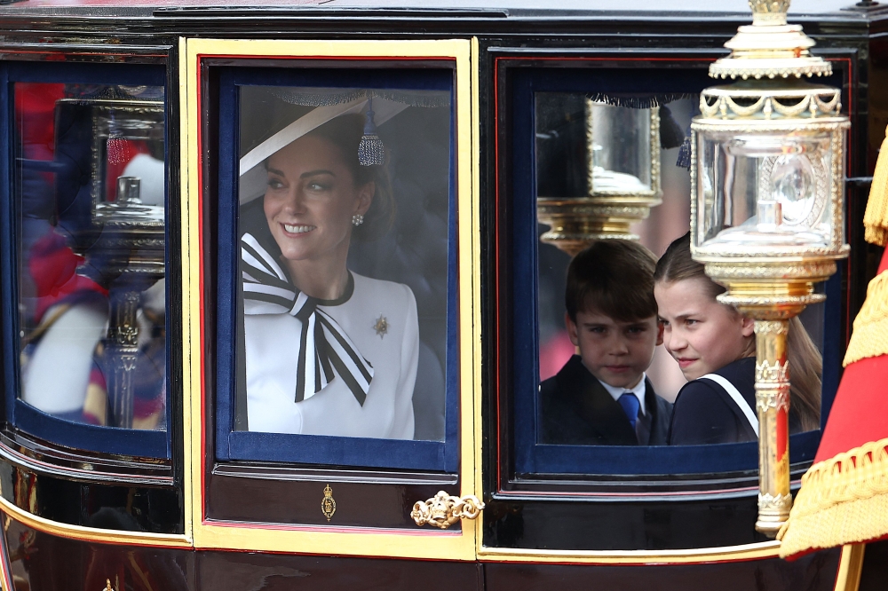 Britain's Catherine, Princess of Wales, smiles next to Britain's Princess Charlotte of Wales (R) and Britain's Prince Louis of Wales (C) inside the Glass State Coach on June 15, 2024. (Photo by Henry Nicholls / AFP)