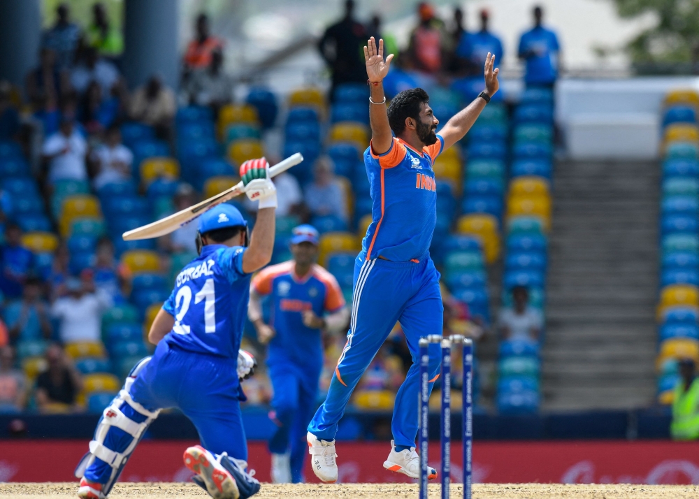 India's Jasprit Bumrah celebrates the dismissal of Afghanistan's Rahmanullah Gurbaz (left) during the ICC men's Twenty20 World Cup 2024 Super Eight cricket match between Afghanistan and India at Kensington Oval in Bridgetown, Barbados, on June 20, 2024. (Photo by Randy Brooks / AFP)