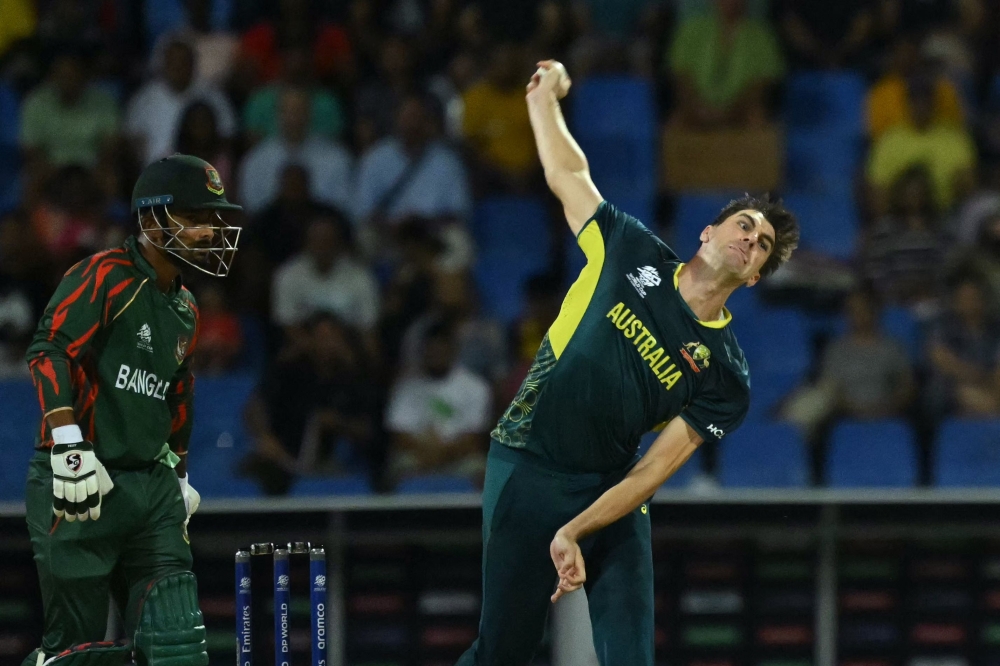 Australia's Pat Cummins bowls as Bangladesh's Litton Das looks on during the ICC men's Twenty20 World Cup 2024 Super Eight cricket match between Australia and Bangladesh at Sir Vivian Richards Stadium in North Sound, Antigua and Barbuda, on June 20, 2024. (Photo by ANDREW CABALLERO-REYNOLDS / AFP)
