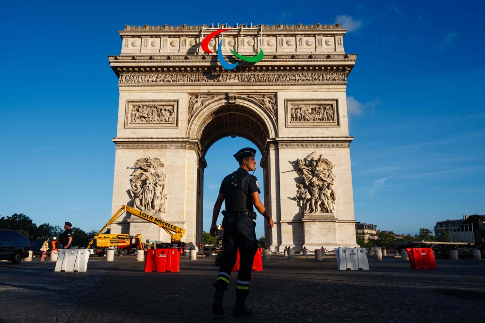Workers install the Agitos, the symbol of the Paralympic Games on the Arc de Triomphe ahead of the upcoming Paris 2024 Olympic Games and Paralympic Games in Paris on June 28, 2024. (Photo by Dimitar Dilkoff / AFP)
