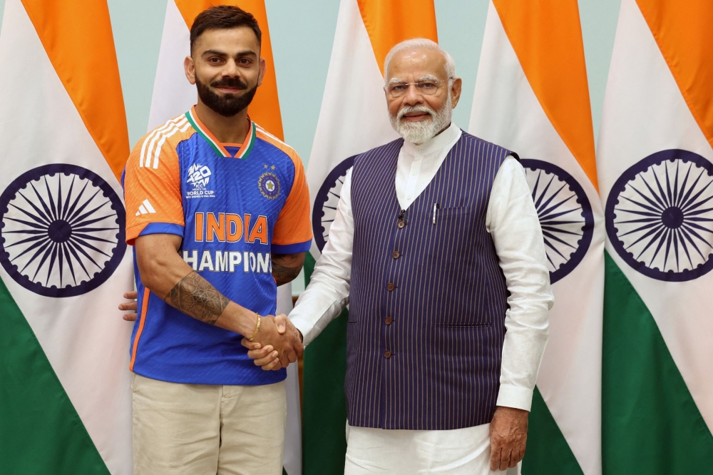 In this handout photograph taken and released on July 4, 2024 by the Indian Press Information Bureau (PIB), India's Prime Minister Narendra Modi shakes hands with Indian cricketer Virat Kohli in New Delhi, after India won the ICC men's Twenty20 World Cup 2024 in Barbados. (Photo by PIB / AFP)