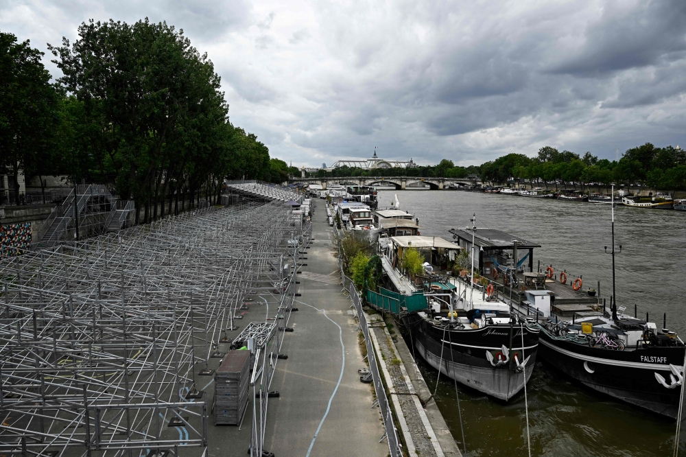 A general view shows stands under construction along the banks of the Seine River ahead of the upcoming Paris 2024 Olympics, in Paris on July 3, 2024. (Photo by JULIEN DE ROSA / AFP)

