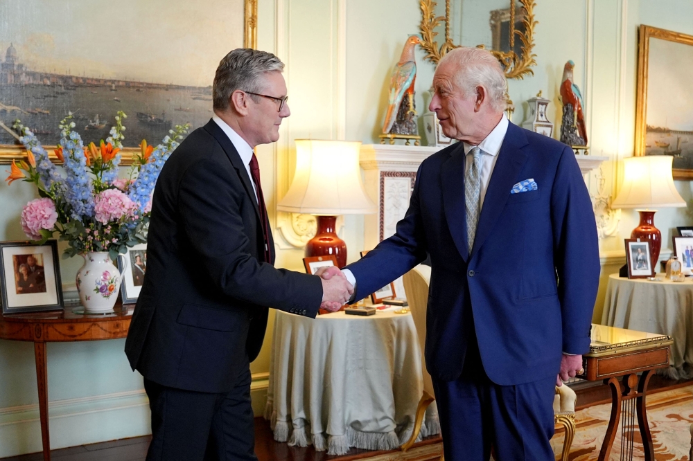 Britain's King Charles III (right) welcomes Britain's incoming Prime Minister Keir Starmer during an audience at Buckingham Palace in London on July 5, 2024, a day after Britain held a general election. (Photo by Yui Mok / POOL / AFP)