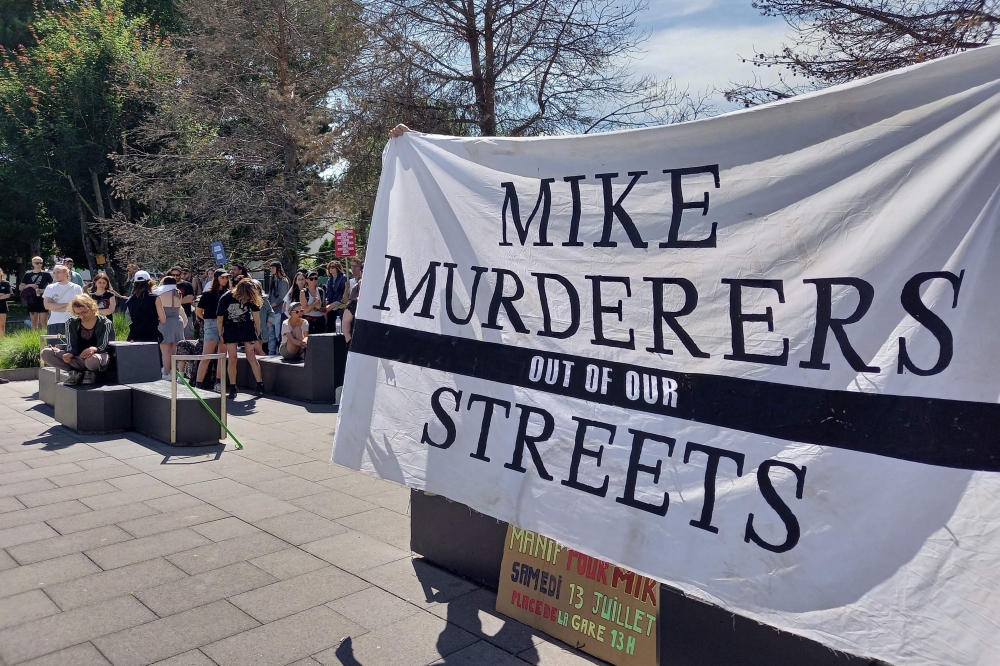 Activists hold a banner in front of the criminal court during an appeal trial of six police officers involved in the arrest that led to Mike Ben Peter's death, in Renens, western Switzerland, on July 8, 2024. (Photo by Robin MILLARD / AFP)
