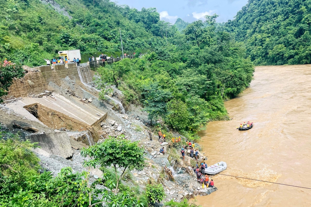 Rescuers search for survivors in river Trishuli in Simaltar on July 12, 2024, at the site of a landslide. (Photo by Rajesh Ghimire / AFP)
