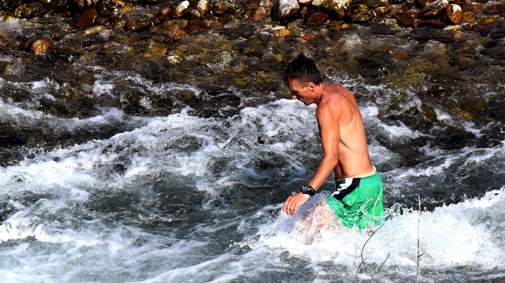 A man bathes on the banks of river Cijevna, in the outskirts of the city, as temperatures reach as high as 42 degrees Celsius amid a heat wave, in Podgorica on July 15, 2024. (Photo by SAVO PRELEVIC / AFP)
