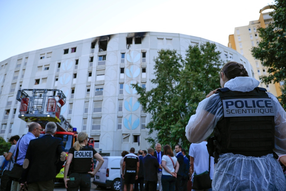 A Forensic police officer works outside a building after French Firefighters extinguishing a fire that broke out overnight at a residential building in a working-class neighbourhood of the southern French city of Nice, killed seven people, southern France, on July 18, 2024. (Photo by Valery HACHE / AFP)
