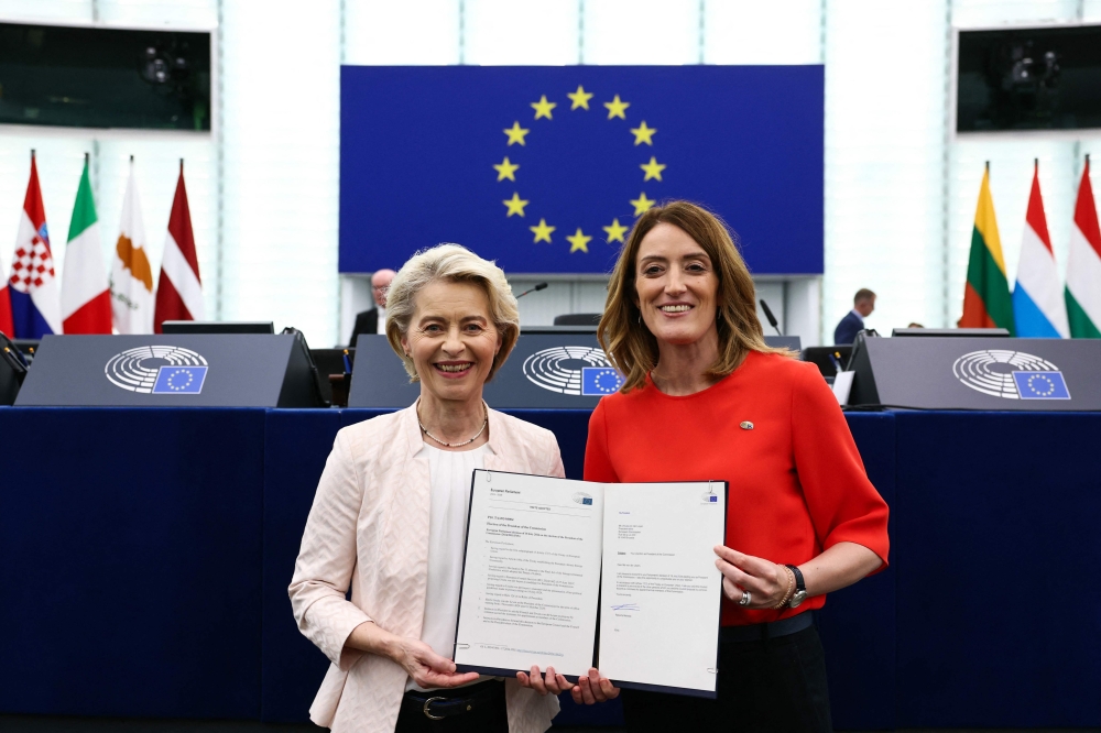 Ursula von der Leyen (R) poses next to European Parliament President Roberta Metsola (R) with document after being elected to a second term as president of the European Commission at the European Parliament in Strasbourg, eastern France, on July 18, 2024. Photo by FREDERICK FLORIN / AFP