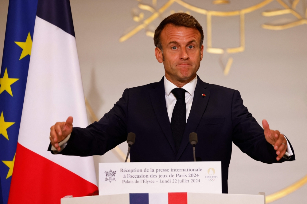 France's President Emmanuel Macron gestures as he delivers a speech during a reception for international journalists accredited for the Paris 2024 Olympic Games at the Elysee Presidential Palace, in Paris on July 22, 2024, ahead of Paris 2024 Olympic and Paralympic games. (Photo by Ludovic MARIN / AFP)
