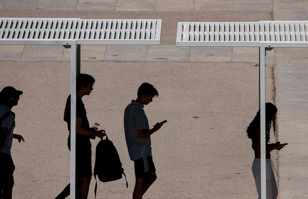 Tourists queue under a shade at the Palacio Real amid heatwave conditions in Madrid on July 23, 2024. (Photo by Oscar Del Pozo / AFP)
 
