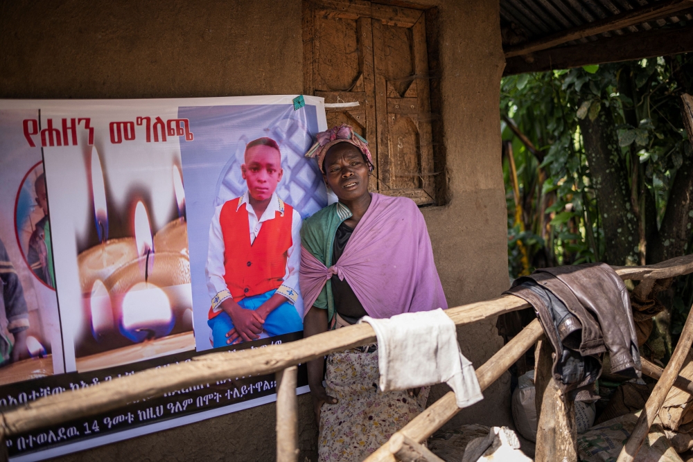 A woman leans against a commemorative poster of a family member perished during a nearby landslide in Kencho Shacha Gozdi on July 25, 2024. (Photo by Michele Spatari / AFP)
