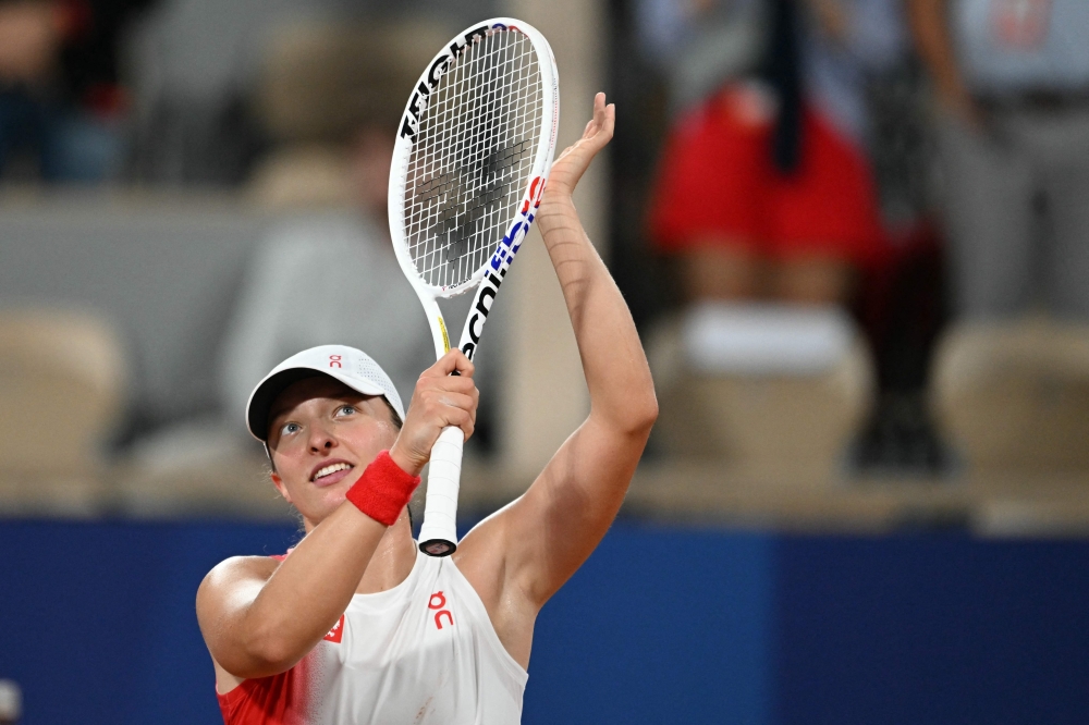 Poland's Iga Swiatek reacts after beating Romania's Irina-Camelia Begu in their women's singles first round tennis match on July 27, 2024. (Photo by Patricia De Melo Moreira / AFP)
 