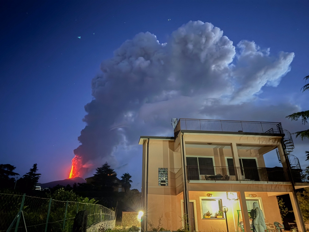 Lava, steam and ashes spew from a crater of the Mount Etna volcano early on August 4, 2024 in Sicily. (Photo by Giuseppe Distefano / Etna Walk / AFP)

