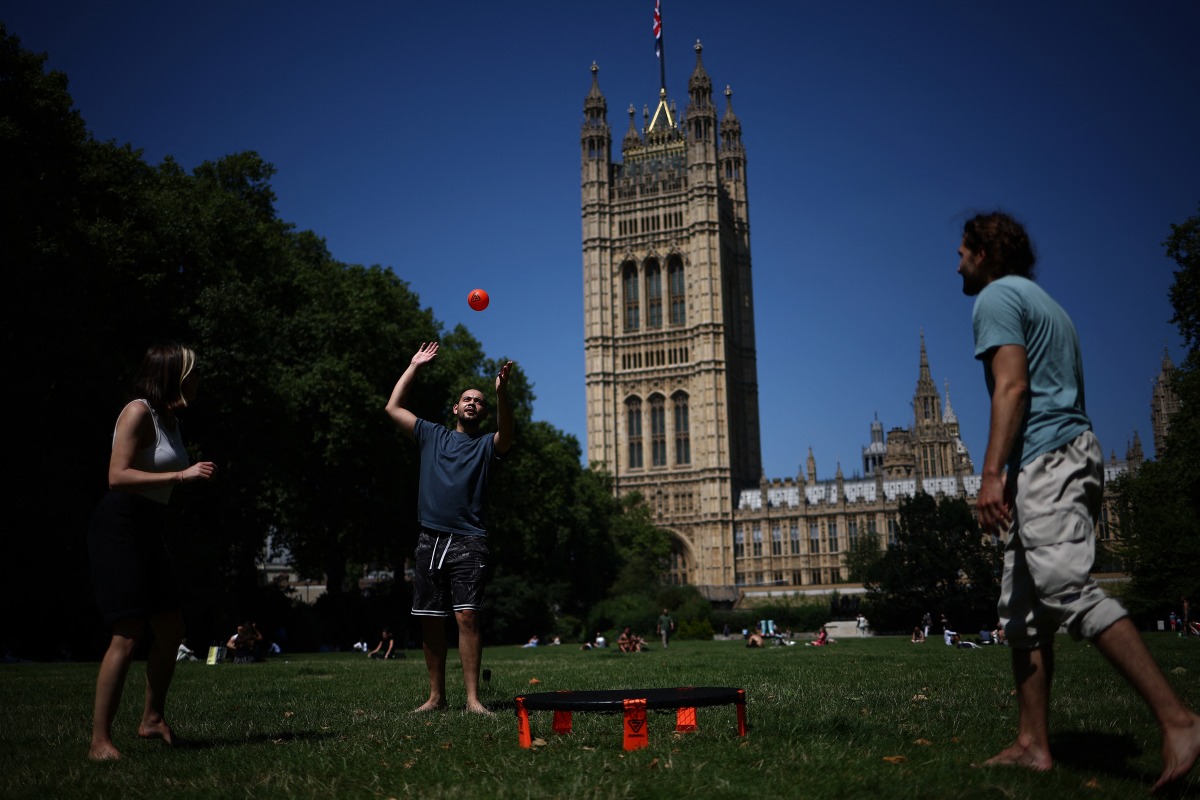 People play in the sunshine in Victoria Tower Gardens near the Houses of Parliament, in central London, on July 30, 2024. (Photo by HENRY NICHOLLS / AFP)