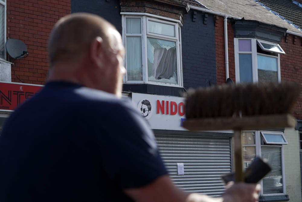 Members of the local community help to clear debris from the streets in Middlesbrough, north east england on August 5, 2024, following rioting and looting the day before. (Photo by Yelim LEE / AFP)
