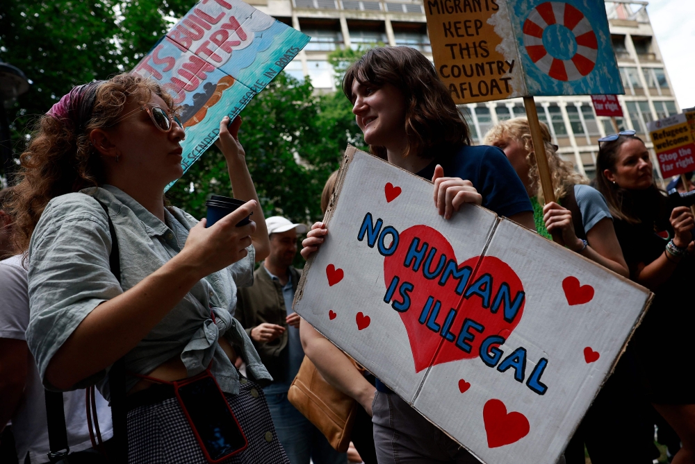 People hold anti-racist placards as they take part in a 