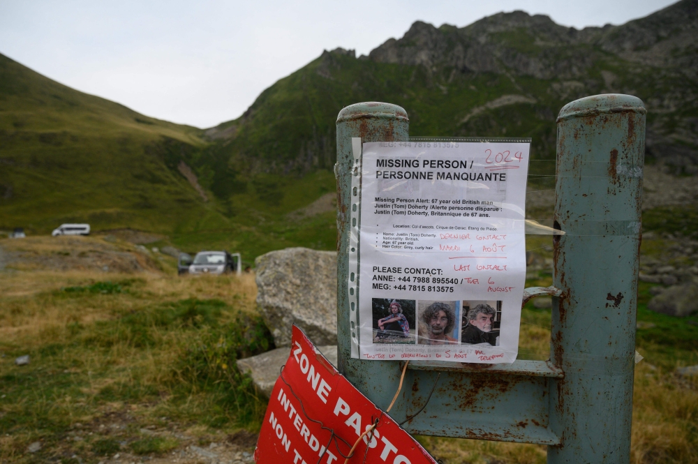 A missing person sign for British hiker Tom Doherty is seen attached to a metal post near Ustou, in the French Pyrenees between Col d'Escots and Cirque de Gerac on August 11, 2024. (Photo by Ed JONES / AFP)