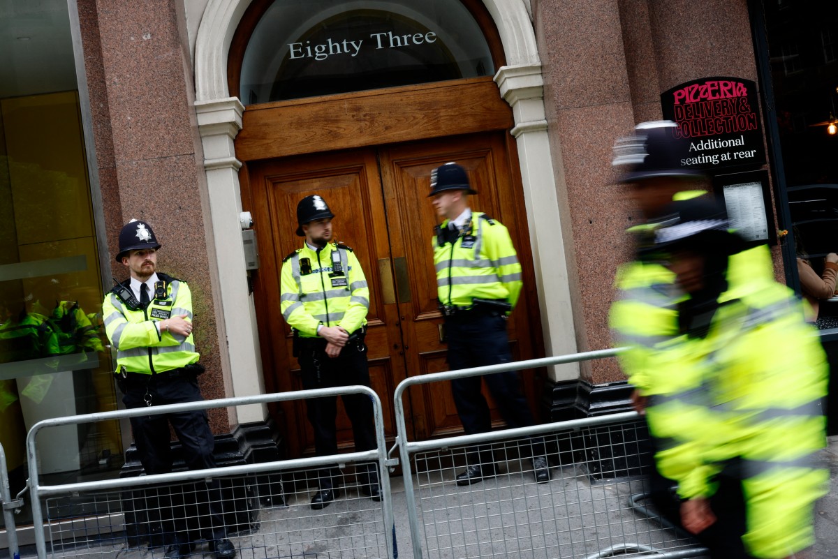 Police officers stand on duty outside the entrace to a building housing the headquarters of the Reform UK political party in London on August 10, 2024. Photo by BENJAMIN CREMEL / AFP.