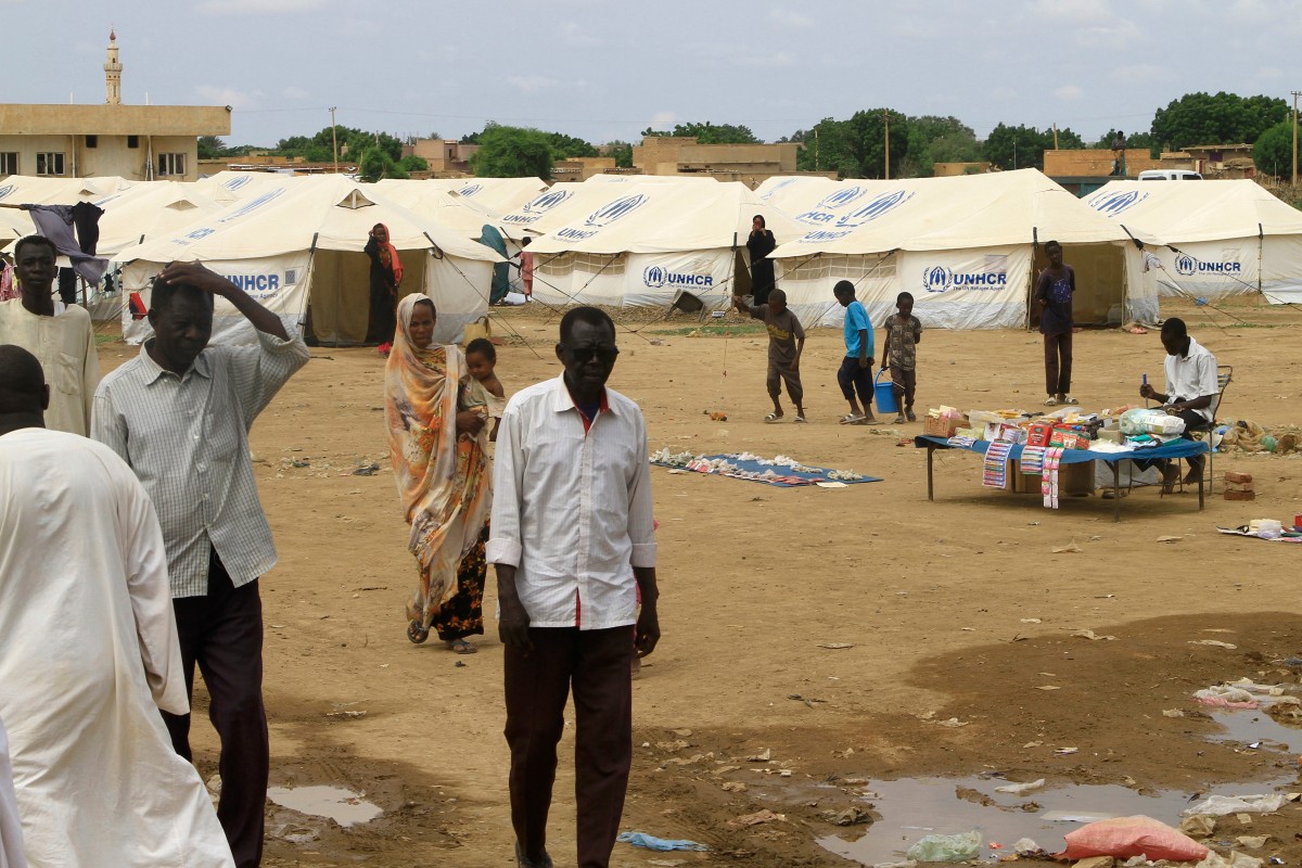 Sudanese already displaced by conflict, walk near tents at a makeshift campsite they were evacuated to following deadly floods in the eastern city of Kassala on August 12, 2024. (Photo by AFP)
