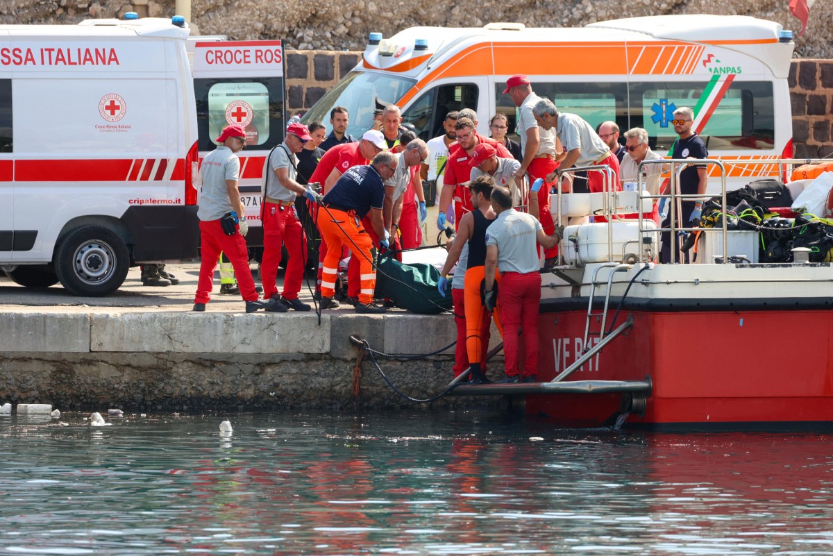 Italian firefighters and health workers carry a body bag with a victim after a sailboat sank off the coast of Porticello, nosthwestern of Sicily Island, on August 19, 2024. Photo by Igor Petyx / ANSA / AFP.