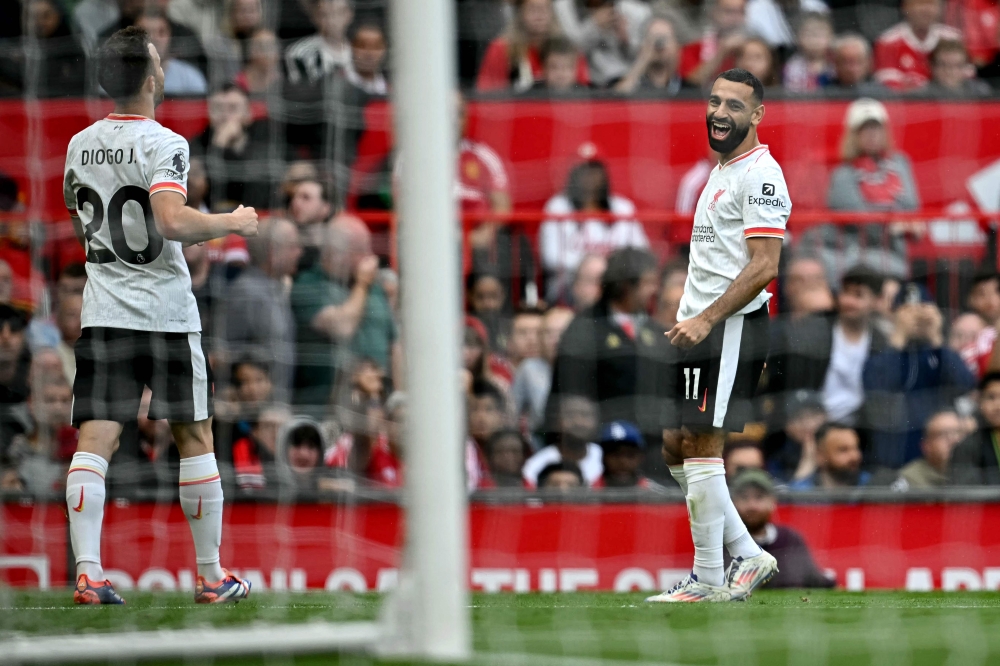 Liverpool's Egyptian striker #11 Mohamed Salah (R) celebrates with Liverpool's Portuguese striker #20 Diogo Jota after scoring the team's third goal during the English Premier League football match between Manchester United and Liverpool at Old Trafford in Manchester, north west England, on September 1, 2024. (Photo by Paul ELLIS / AFP)
