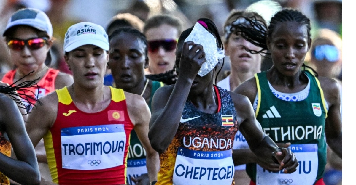 Uganda's Rebecca Cheptegei (C) applies an ice bag on her head as she competes in the women's marathon of the athletics event at the Paris 2024 Olympic Games in Paris on August 11, 2024. Photo by Kirill KUDRYAVTSEV / AFP.