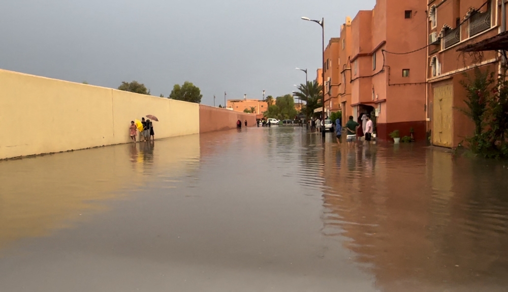 Residents walk on a flooded street in Morocco's Ouarzazate city on September 7, 2024. Photo by Abderahim ELBCIR / AFP