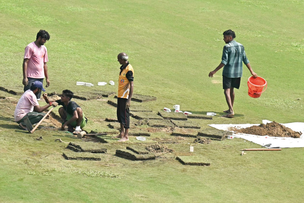Groundsmen prepare the field with artificial grass before the start of the one-off Test between Afghanistan and New Zealand at the Shaheed Vijay Singh Pathik Sports Complex in Greater Noida.
