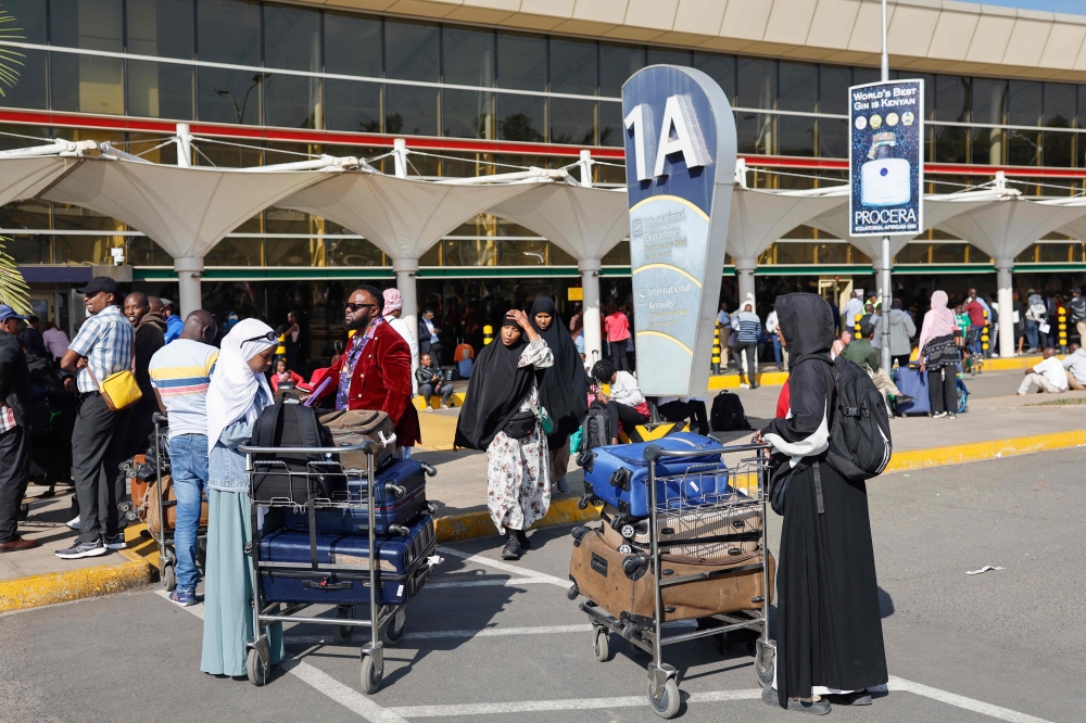Passengers wait at a closed door at the departures of the Jomo Kenyatta International Airport (JKIA) in Nairobi on September 11, 2024. (Photo by Simon Maina / AFP)