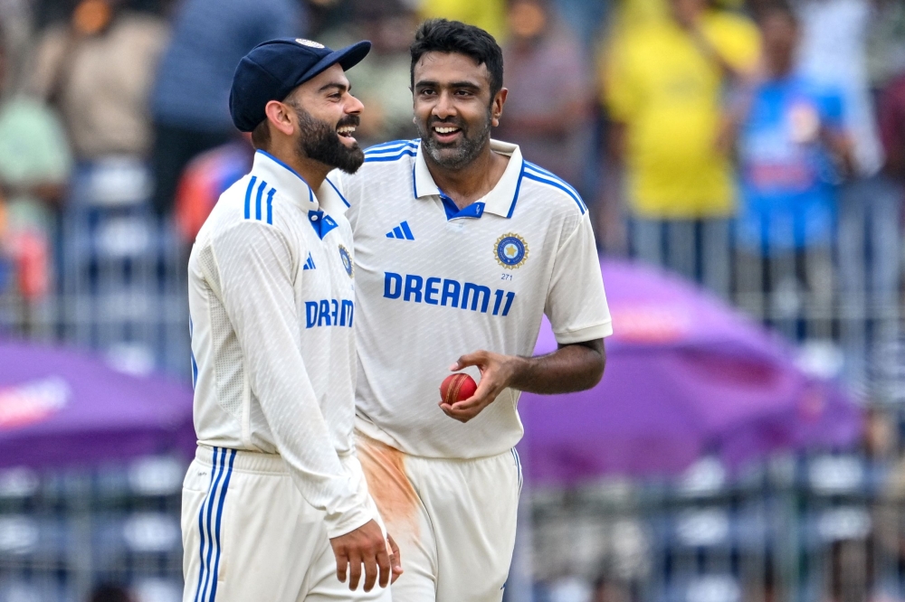 India's Ravichandran Ashwin (R) celebrates with teammate Virat Kohli after taking the wicket of Bangladesh's Mehidy Hasan Miraz on September 22, 2024. (Photo by R.Satish BABU / AFP)