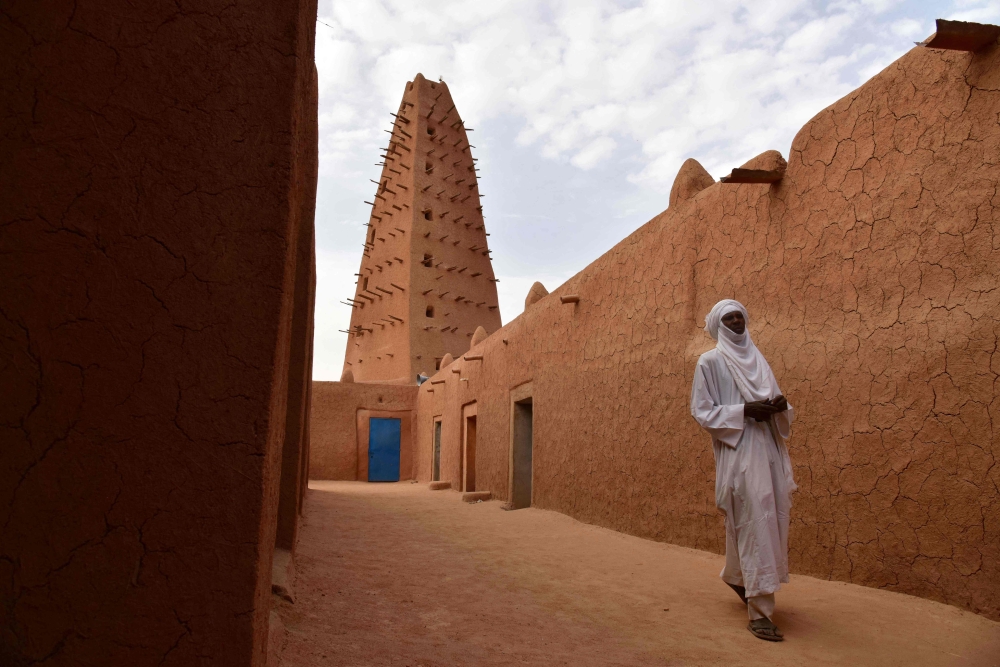 (Files) A man walks in the vicinity of a earthen mud mosque in Agadez, in northern Niger, on April 2, 2017. (Photo by Issouf Sanogo / AFP)