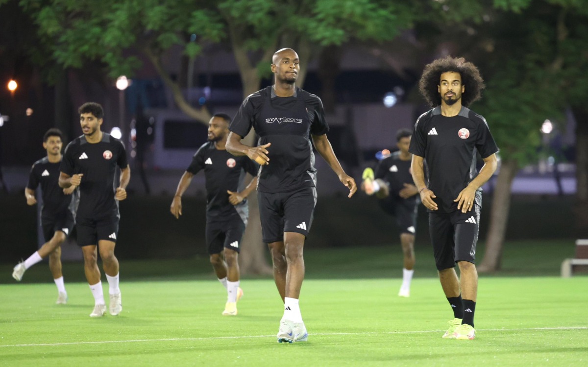 Qatar's Abdelkarim Hassan (centre) with Akram Afif (right) during a training session yesterday.