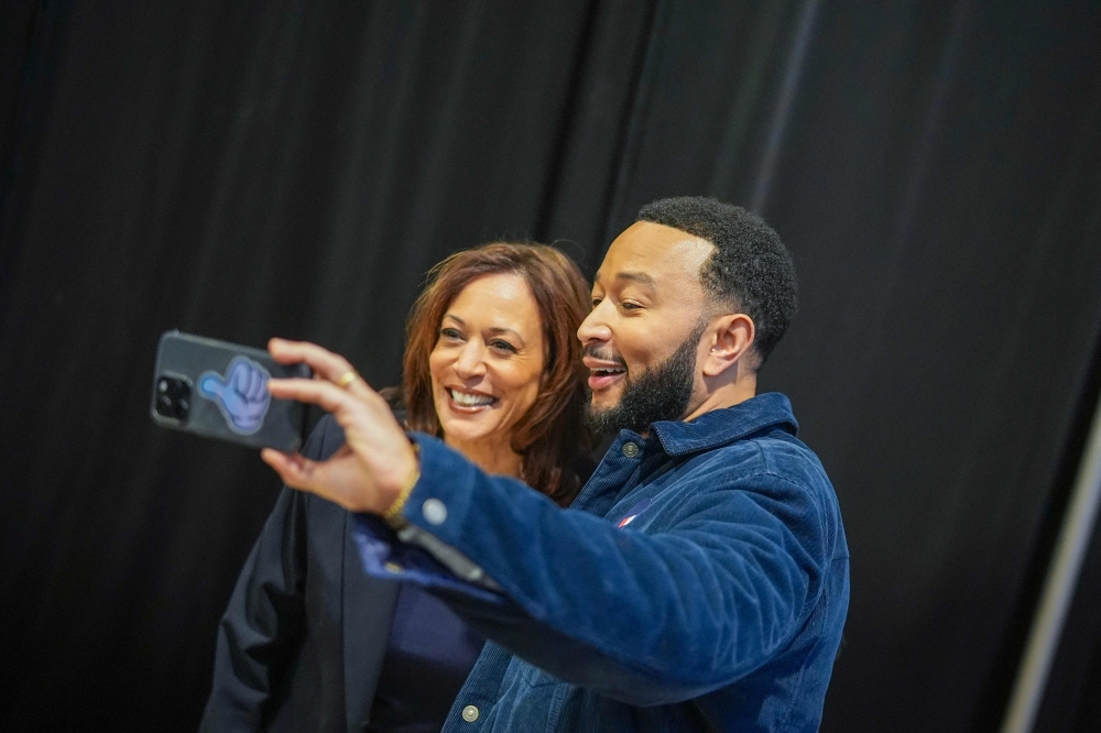 Democratic presidential nominee, US Vice President Kamala Harris takes a selfie with musician John Legend before she speaks during a campaign rally at The Alan Horwitz