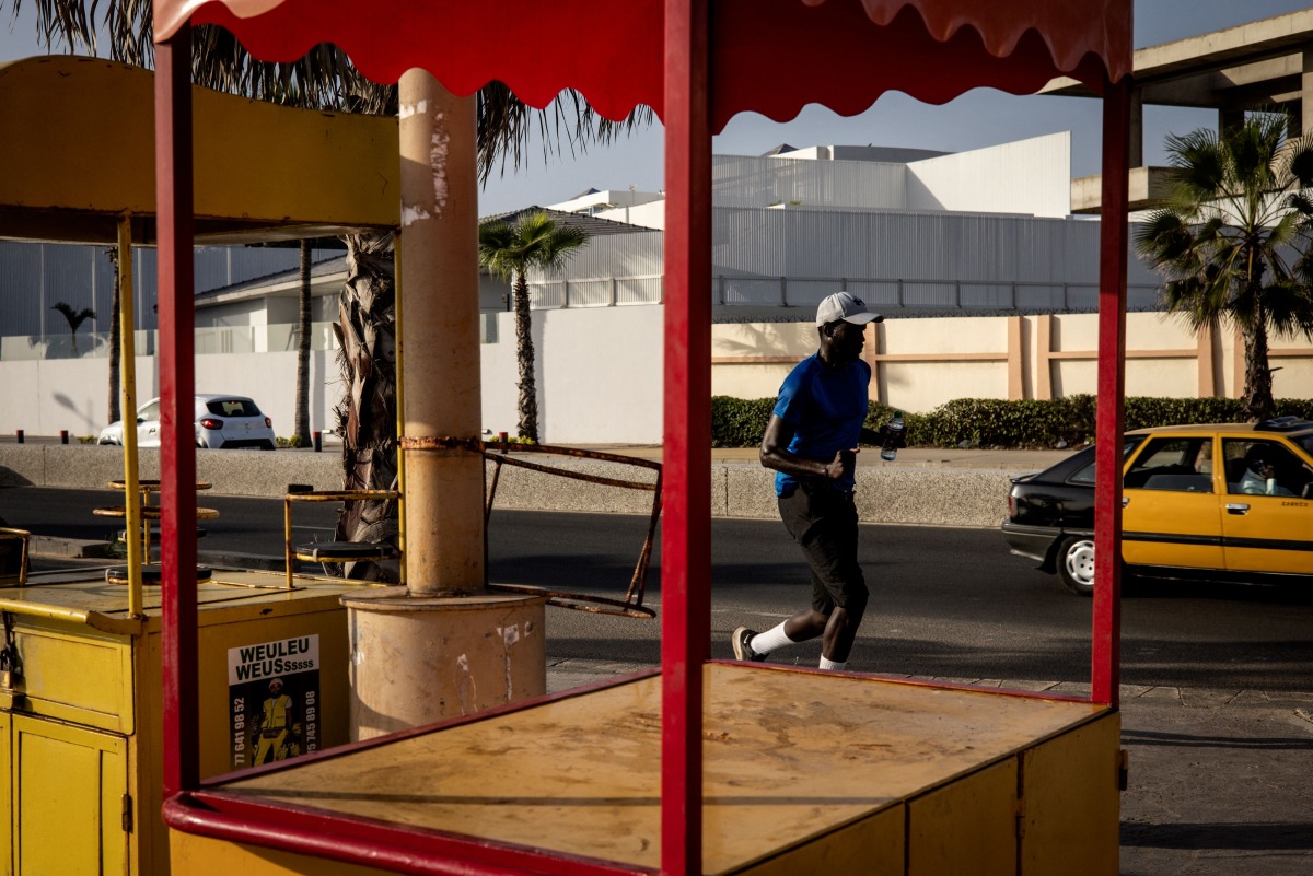 A man runs along the corniche in Dakar on October 29, 2024. (Photo by JOHN WESSELS / AFP)

