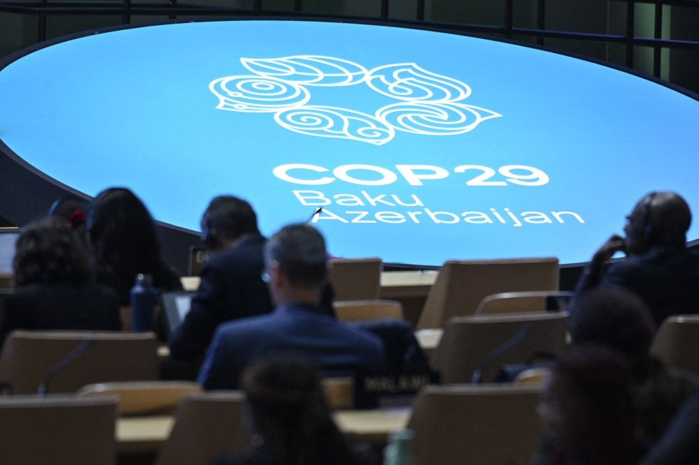 Participants listen to speeches during the United Nations Climate Change Conference (COP29) in Baku on November 13, 2024. (Photo by Alexander Nemenov / AFP)