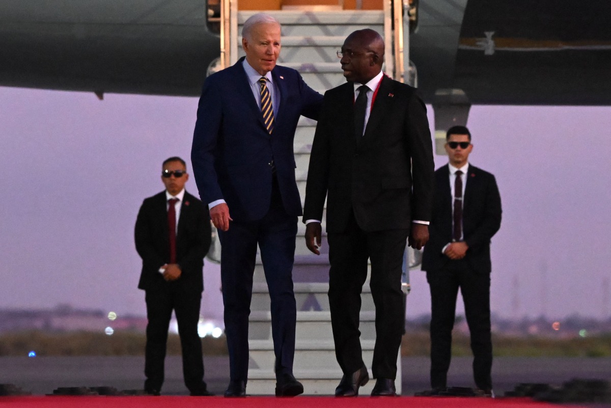 US President Joe Biden (3rd R) walks on the red carpet next to Angola Foreign Affairs Minister Tete Antonio (2nd R) upon his arrival at the Quatro de Fevereiro Luanda International Airport in Luanda on December 2, 2024. (Photo by ANDREW CABALLERO-REYNOLDS / AFP)
