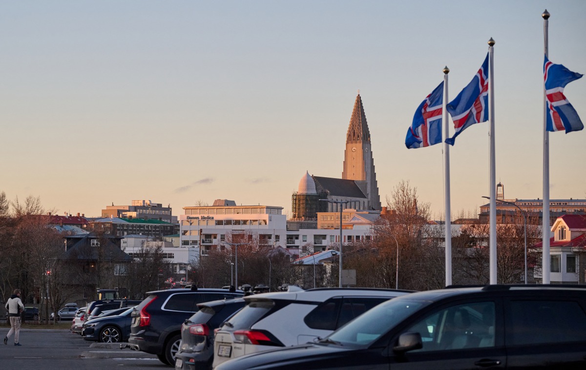 Icelandic national flags are seen flying outside as the Hallgrimskirkja church is seen in the background, in Reykjavik, Iceland, on November 30, 2024. (Photo by Halldor Kolbeins / AFP)
