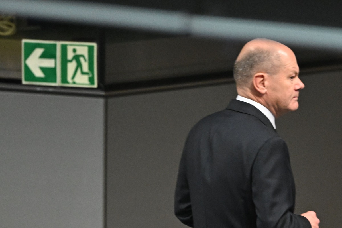 German Chancellor Olaf Scholz is pictured next to an exist sign during a vote of confidence against himself in a plenary session at the Bundestag (Lower house of Parliament) in Berlin on December 16, 2024. (Photo by RALF HIRSCHBERGER / AFP)
