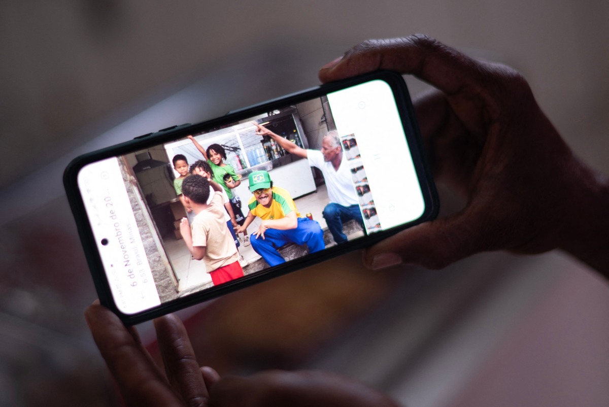 Ronaldo Teixeira, owner of the establishment, shows a photo of him with singer Bruno Mars at the establishment in Belo Horizonte, Brazil, on December 11, 2024. Photo by Douglas MAGNO / AFP