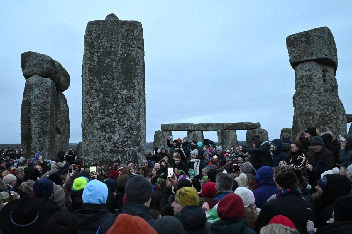 Revellers celebrate the pagan festival of 'Winter Solstice' at Stonehenge in Wiltshire in southern England on December 21, 2024. (Photo by JUSTIN TALLIS / AFP)
