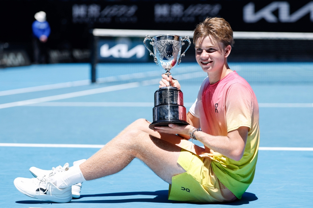 Switzerland's Henry Bernet poses with the winner's trophy after his victory in junior boys' singles final match in Melbourne on January 25, 2025. (Photo by Martin Keep / AFP)