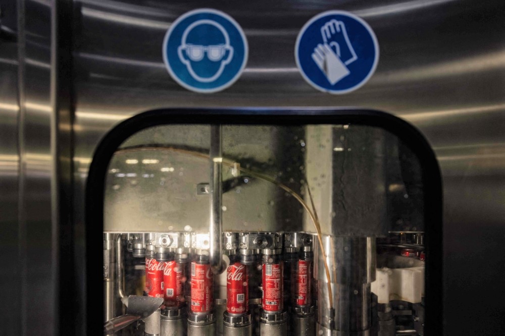 This photograph taken on January 26, 2023 shows cans of Cola at the closing stage at the Coca Cola factory in Bierne, northern France. (Photo by Sameer Al Doumy / AFP)
